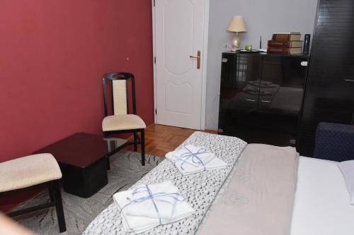 a bedroom with a bed and a desk and a chair at Blue House Apartment in Niš