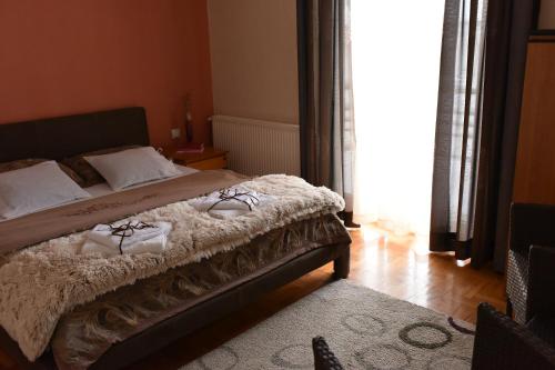 a bedroom with a bed with white sheets and pillows at Blue House Apartment in Niš