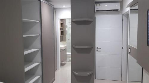 uma cozinha com armários brancos e um frigorífico de vidro em Excelente Apto Terraço Verde C/Vista Mar Piscina 3 D em Capão da Canoa