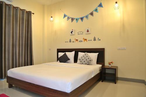 a bedroom with a large bed with white sheets at Instyle Place in Chiang Rai