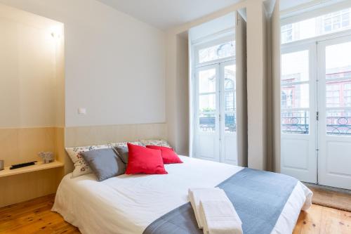 a bedroom with a large white bed with red pillows at House in Porto Historical Center T1 in Porto