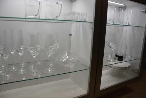 a glass cabinet filled with wine glasses on display at Ostsee-Kay, inklusive Bettwäsche und Handtücher in Graal-Müritz