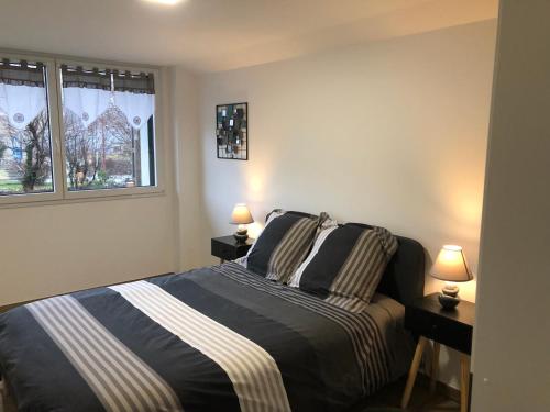 - une chambre avec un lit et deux lampes sur les tables dans l'établissement ELANS, à Gérardmer