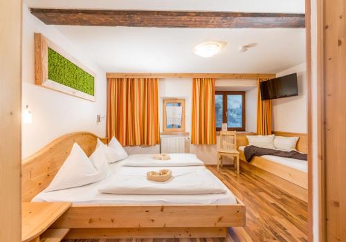 a hotel room with two beds and a tv at Das kleine Bio Hotel Tiefenbach in Schladming