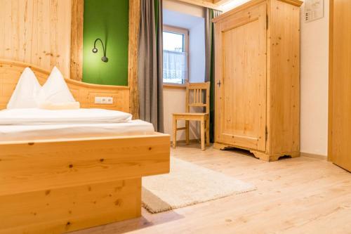 a bedroom with a bed and a green wall at Das kleine Bio Hotel Tiefenbach in Schladming