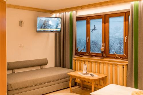 een woonkamer met een bank en een raam bij Das kleine Bio Hotel Tiefenbach in Schladming