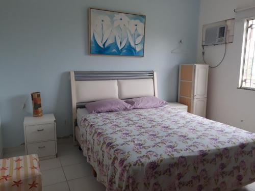 a bedroom with a bed with a purple comforter at Solar das Ostras Salinopólis in Salinópolis