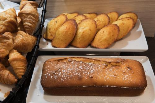 a tray with different types of bread and pastries at Mercure Paris Pont de Levallois Neuilly in Levallois-Perret