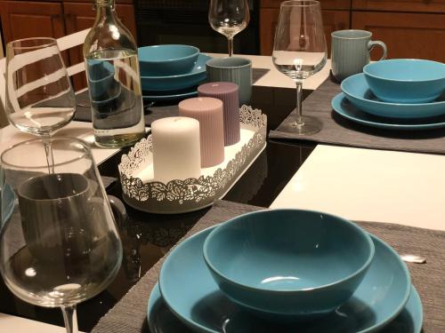 a table with blue plates and wine glasses on it at Apartment Gulek in Zreče