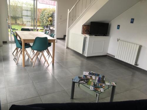 a living room with a table and chairs and a tv at Véro, Yves in Nay