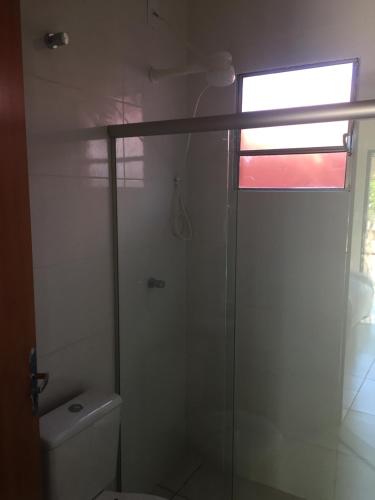 uma casa de banho com uma cabina de duche em vidro e um WC. em Flat Thermas Olimpia - 300 metros do Thermas dos Laranjais em Olímpia