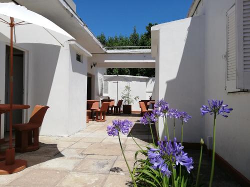 a patio with purple flowers in a yard at Parque Hotel in Santa Teresita