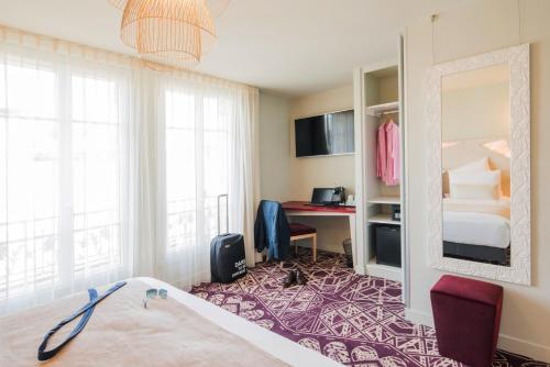 a hotel room with a bed and a mirror at Mercure Paris Pont de Levallois Neuilly in Levallois-Perret