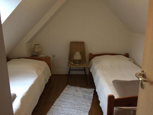 a bedroom with two beds and a chair at Schaalseeblick in Zarrentin