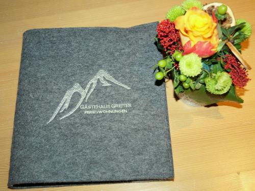 a sign on a table with a bouquet of flowers at Gästehaus Greiter - Sommer Bergbahnen inklusive in Oberstdorf