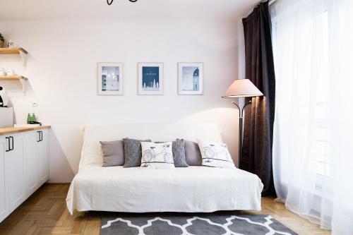 ワルシャワにあるArkadia Chillout Apartmentの白いベッドルーム(ベッド1台、ランプ付)