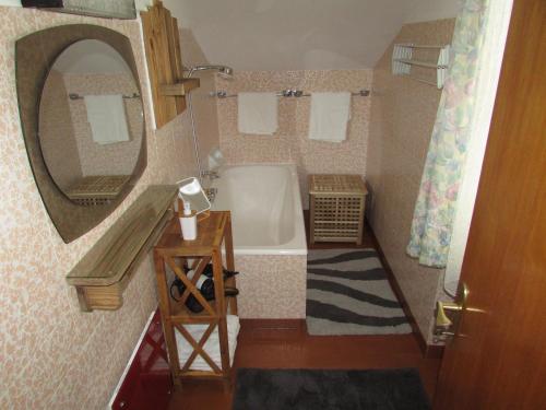 a bathroom with a tub and a sink and a mirror at Ferienhaus Tschenett in Imst