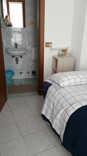 a bathroom with a bed and a sink and a shower at Foresteria Lombarda da Giovanna in Barzio