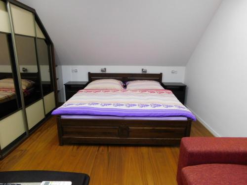 Un dormitorio con una cama con sábanas moradas y espejos en Apartmánový Penzión Bojnice en Bojnice