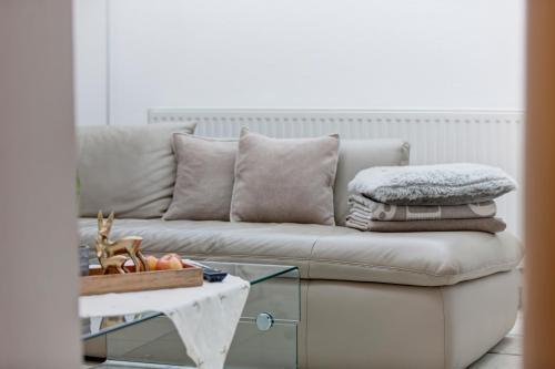 a living room with a couch and a glass table at Am Dorfplatz Suites - Adults friendly in Sankt Anton am Arlberg