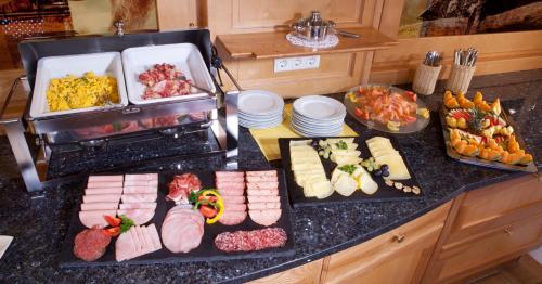 una mesa con un montón de diferentes tipos de comida en Hotel Waldfrieden, en Schladming