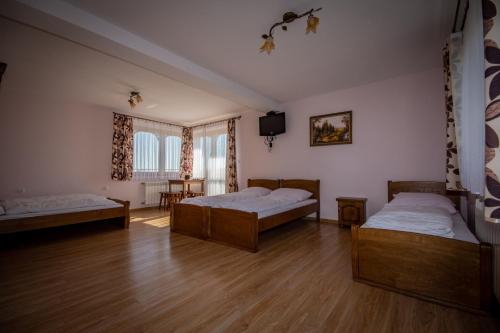 two beds in a room with wooden floors at Podhalanski Dworek SPA in Białka Tatrzańska