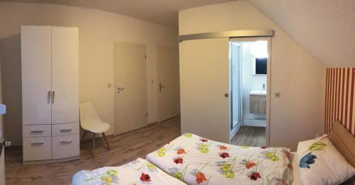een kleine slaapkamer met een bed en een stoel erin bij Ferienwohnungen Haus Landmann in Hahnenklee-Bockswiese
