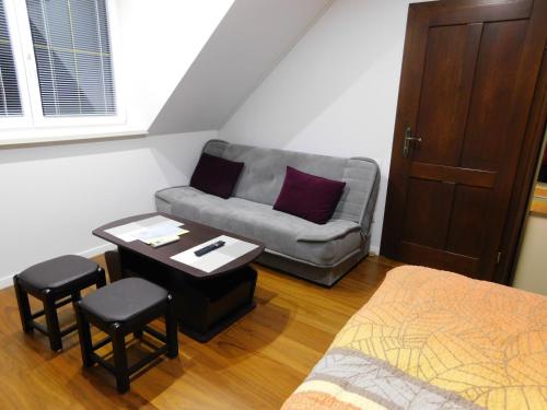 a bedroom with a couch and a table and a bed at Apartmánový Penzión Bojnice in Bojnice