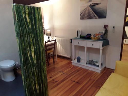 a room with a toilet and a table and a desk at Chambre Sergeanne in Doulezon