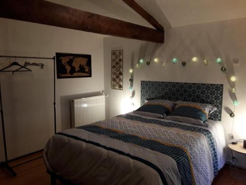 una camera da letto con un grande letto con luci sopra di Chambre Sergeanne a Doulezon