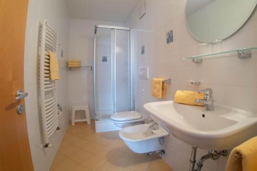 ein Badezimmer mit einem Waschbecken, einem WC und einem Spiegel in der Unterkunft App. Tamanhof in St. Georgen