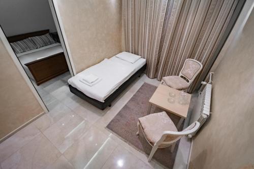 a small room with a bed and a table and a chair at Hotel Dunav Požarevac in Požarevac