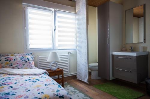 a bedroom with a bed and a sink and a toilet at Annette's Home in Mazingarbe