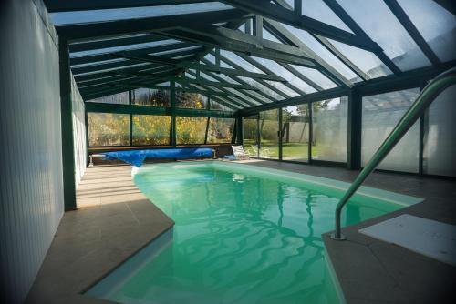 a swimming pool in a house with a glass ceiling at Annette's Home in Mazingarbe