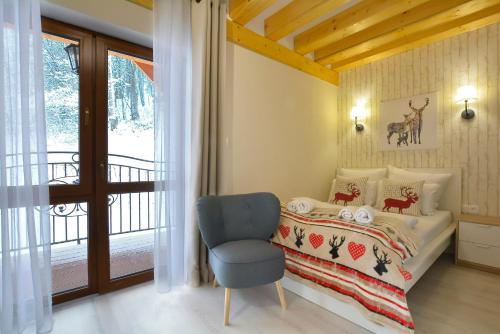 sypialnia z łóżkiem, krzesłem i oknem w obiekcie Zlote Modrzewie w mieście Duszniki Zdrój