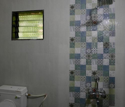 a bathroom with a toilet and a window at Angelo's place in Arambol