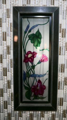 a glass picture of flowers on a wall at Angelo's place in Arambol