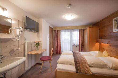 a hotel room with a bed and a sink at Anja's Schönblick - Bed & Breakfast in Gerlos