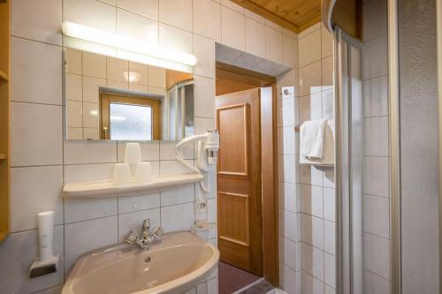 a bathroom with a sink and a mirror at Anja's Schönblick - Bed & Breakfast in Gerlos