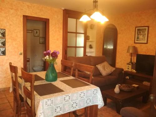 ein Wohnzimmer mit einem Tisch und einer Blumenvase darauf in der Unterkunft Villa Las Encinas COSTA DEL SOL in Torrox