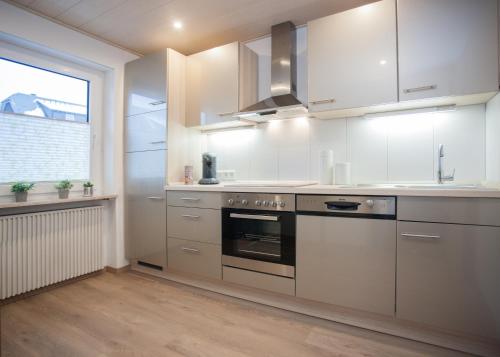una cocina con electrodomésticos de acero inoxidable y una ventana en Ferienwohnungen Citylight Winterberg, en Winterberg