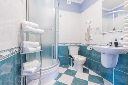 W łazience znajduje się umywalka, toaleta i prysznic. w obiekcie Hotel Fryderyk w mieście Duszniki Zdrój