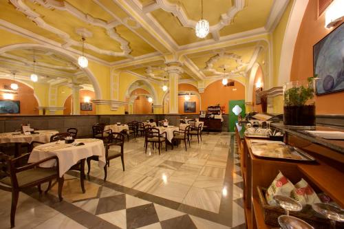 a restaurant with tables and chairs in a room at Hotel Inglaterra in Granada