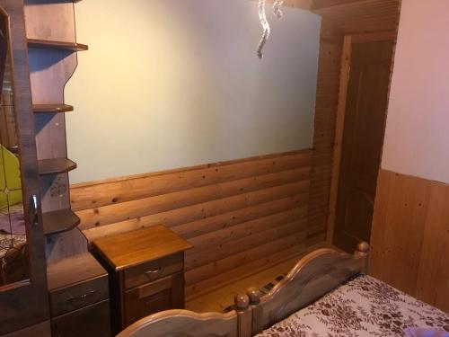 a room with a tub in a room with wooden walls at Shelest Vody in Russkaya Mokraya