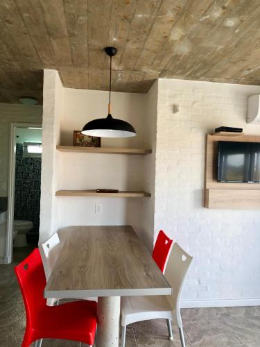 a dining room with a table and two red chairs at Las Olas Aparts in La Paloma