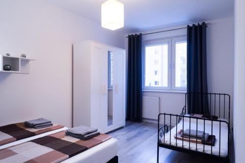 a white room with two beds and a window at APARTAMENT FOCUS in Gdynia