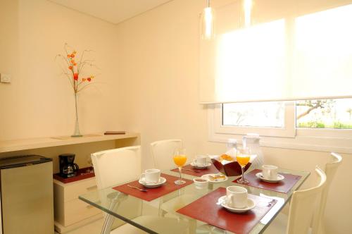 ein Esszimmer mit Glastisch und Stühlen in der Unterkunft Arenas Blancas Cabañas & Suites in Nono