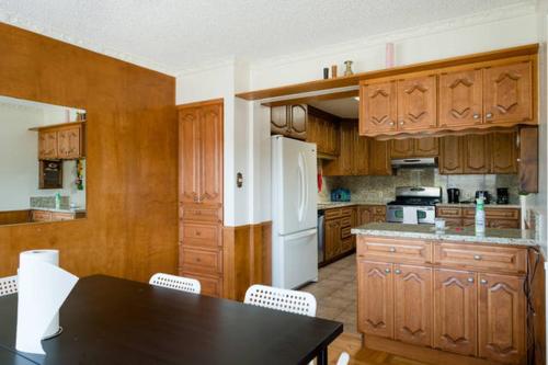 a kitchen with a table and a white refrigerator at Hostel Style Shared Room in Daly City