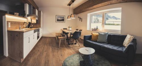 Haus Schlager "dasAppartement" في أنابيرغ ام لاميرتا: غرفة معيشة ومطبخ مع أريكة وطاولة