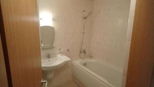 a bathroom with a sink and a tub and a toilet at Studio L006 in Aspen Golf in Bansko